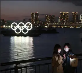  ?? JAE C. HONG — THE ASSOCIATED PRESS ?? Two women take a selfie with the Olympic rings in the background in the Odaiba section of Tokyo on March 12.