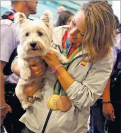  ??  ?? RECIBIMIEN­TO. Mireia Belmonte, con su perro Londo, en Barcelona.