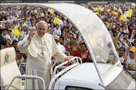  ?? GEMUNU AMARASINGH­E / ASSOCIATED PRESS ?? Pope Francis waves en route to a Mass before a reported 150,000 people Wednesday in Yangon, Myanmar. In his homily, Francis acknowledg­ed the suffering that Myanmar’s ethnic and religious groups have endured.