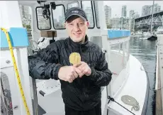  ?? JASON PAYNE ?? Michael Smith’s son Tom, holding a replica of his father’s Nobel Prize medallion, says his dad was passionate about the outdoors and that they were “lucky” to grow up in Vancouver.