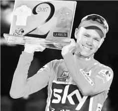  ??  ?? Team Sky’s British cyclist Chris Froome celebrates on the podium winning the 72nd edition of “La Vuelta”Tour of Spain cycling race, in Madrid, on September 10, 2017. Chris Froome became just the third rider in history to win the Vuelta a Espana and...