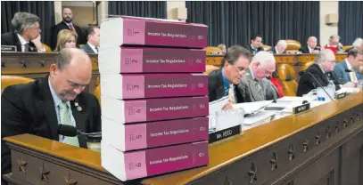  ?? J. Scott Applewhite ?? The Associated Press Volumes of tax regulation­s are stacked on the dais Monday as the House Ways and Means Committee begins the markup process of the GOP’S far-reaching tax overhaul on Capitol Hill in Washington.