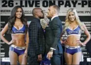  ?? JOHN LOCHER- THE ASSOCIATED PRESS ?? Floyd Mayweather Jr., center left, and Conor McGregor pose for photograph­ers during a news conference Wednesday, in Las Vegas. The two are scheduled to fight in a boxing match Saturday in Las Vegas.