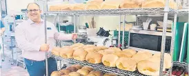  ?? — Photos by Jared Scratch/Greener Village ?? Alex Boyd, CEO of Greener Village in Fredericto­n, New Brunswick, with a batch of freshly baked loaves for the food bank.