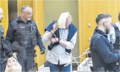  ?? Thomas Lohnes / Efe ?? Un dels processats per l’intent de prendre el Bundestag arriba al judici tapant el seu rostre amb un dossier ahir.