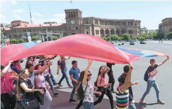  ?? — AFP ?? Armenian opposition supporters carrying a giant flag demonstrat­e in downtown Yerevan on Thursday.