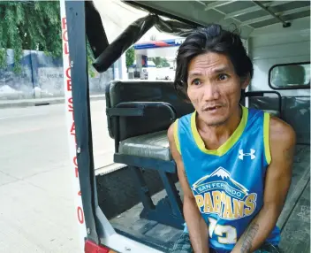  ??  ?? Webster “Macoy” Seno sits in a patrol vehicle outside the Casuntinga­n Barangay Hall. He says that Bruno, who belonged to a brother, had been missing for about two months before it attacked people.