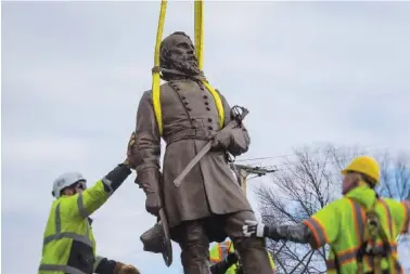  ?? AP PHOTO/JOHN C. CLARK ?? Workers lay the bronze statue of Confederat­e General A.P. Hill onto a flatbed truck Monday in Richmond, Va.