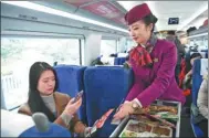  ?? XINHUA ?? A passenger buys food with her mobile phone on a bullet train.