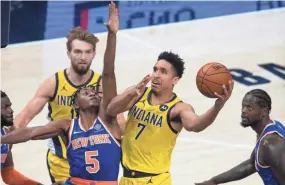  ?? TREVOR RUSZKOWSKI/USA TODAY SPORTS ?? Pacers guard Malcolm Brogdon (7) shoots the ball while Knicks guard Immanuel Quickley (5) defends in the first quarter.