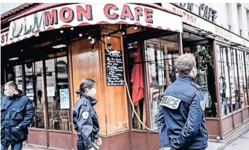  ?? FOTO: STEPHANE DE SAKUTIN/AFP ?? Polizisten kontrollie­ren ein Café in Paris: Immer mehr gastronomi­sche Lokale in Frankreich versuchen, die Corona-bestimmung­en zu umgehen.