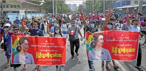  ?? — AFP photos ?? Protesters march with banners with the image of Suu Kyi during a demonstrat­ion against the military coup in Yangon.
