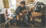  ?? YASUYOSHI CHIBA / AFP VIA GETTY IMAGES ?? A woman sits on her bed with her dog on Thursday at an apartment damaged by a missile explosion in
Kramatorsk in eastern Ukraine.