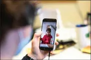  ??  ?? Nine-year-old Porserin receives online help with her schoolwork Tuesday in Berlin. Schools there, closed since before Christmas, are starting to reopen but with restrictio­ns. (AP/Markus Schreiber)