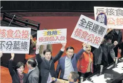  ?? AFP ?? Legislator­s from the main opposition Kuomintang display placards that read “referendum for nuclear polluted food from Japan” inside the Parliament in Taipei on Dec 16.