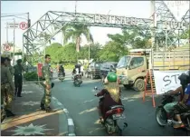  ?? ULUM/JAWA POS ?? TERTIBKAN: Petugas satpol PP berjaga di gerbang masuk jalan utama TPI pada Minggu (31/5). Hari ini warga juga akan mencegah PKL berjualan.