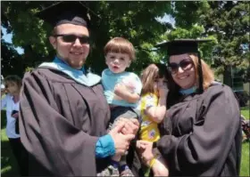  ?? MATT FREY PHOTO ?? Andrew, left, and Casey Zunich, right, a Kingston couple who both received their master’s degrees in education at Mount St. Mary College Saturday, hold their children, Liam, 1, and Sienna, 3. Andrew teaches science at Valley Central High School in Montgomery, N.Y., and Casey teaches math at M. Clifford Miller Middle School in Lake Katrine, N.Y.