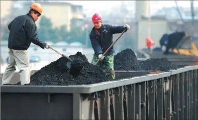  ?? HU GUOLIN / XINHUA ?? Workers load thermal coal at a storage base in Jiujiang, Jiangxi province.