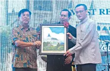  ??  ?? Stephen (left) presents a memento to the Archbishop Most Rev Datuk John Wong (right). Also seen is Father Johnny.