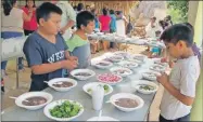  ??  ?? Menores de edad de Ek Balam le añaden cilantro, rábano y limón a su plato de frijol con puerco, luego que les cortaron gratis el cabello