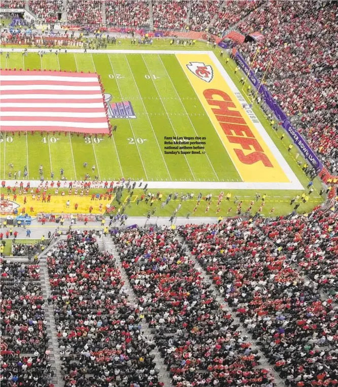  ?? AP ?? Fans in Las Vegas rise as Reba McEntire performs national anthem before Sunday’s Super Bowl.