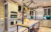  ?? Erik Grammer ?? THE KITCHEN in Raines’ home features stainlesss­teel appliances, black granite counters and a bar.