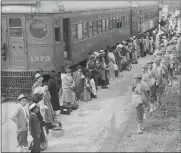  ?? CLEM ALBERS/WAR RELOCATION AUTHORITY/NATIONAL ARCHIVES VIA AP ?? In this photo provided by the National Archives, Japanese Americans from San Pedro, Calif., arrive at the Santa Anita Assembly Center in Arcadia, Calif., on April 5, 1942. People were temporaril­y housed at this center at the Santa Anita race track before being moved inland to internment camps during World War II.