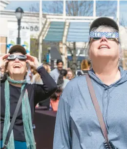  ?? ?? Diane Richter, right, of Upper Saucon Township and Lee Levin-Friend of Emmaus watch the solar eclipse Monday at the Promenade Shops.