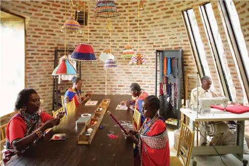  ??  ?? AT THE Safari Shop at Angama Mara lodge in Kenya’s Great Rift Valley, which stocks African-made products, women in traditiona­l shuka robes gather to craft Maasai wooden staffs. | Angama Mara.