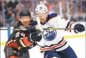  ?? Sean M. Haffey Getty Images ?? THE DUCKS’ Carter Rowney, left, battles the Oilers’ Alex Chiasson for position during the second period.