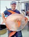  ??  ?? NOAA Fisheries biologist Nick Wegner holds an opah caught during a research survey off the California Coast in this undated handout photo provided by NOAA Fisheries/ Southwest Fisheries Science Center(Reuters)