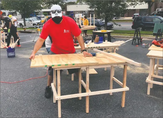  ?? (Courtesy Photo/Jessica Berrellez ) ?? Al Berrellez builds a desk in Gaithersbu­rg, Md., on Sept. 25. Jessica and Al Berrellez, with the help of some 60 community volunteers, have built and donated over 100 desks so far to students and families in need.