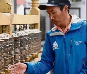  ??  ?? High-altitude life: Kami Rita spinning prayer wheels at Boudhanath Stupa, where he has a rented room, on the outskirts of Kathmandu. — AFP