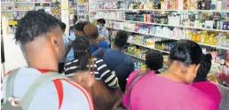  ?? FILE ?? Customers cram Nelson’s Drug Store in Cross Roads on Tuesday. All bottles of hand sanitiser were sold out by Tuesday afternoon.