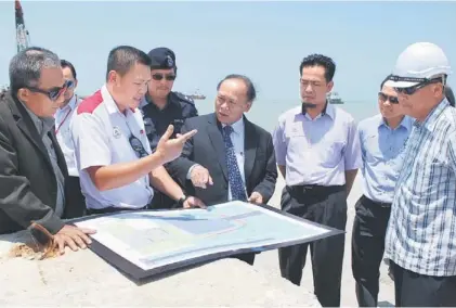  ??  ?? Nansian (fourth right) being briefed on the progress of Samalaju Port developmen­t by a Bintulu Port representa­tive.