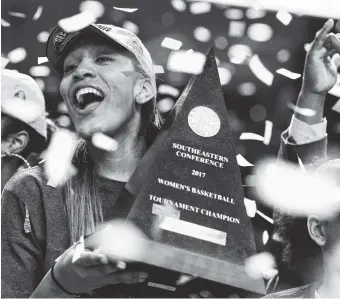 ?? THE ASSOCIATED PRESS ?? South Carolina forward A’ja Wilson celebrates with the trophy after the Gamecocks defeated Mississipp­i State 59-49 in Sunday’s Southeaste­rn Conference tournament final in Greenville, S.C.