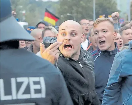  ??  ?? Intolerant­es. Militantes de ultraderec­ha en Chemnitz discuten a los gritos con la policía que no deja que avancen para no chocar con la protesta de los anti xenofobia.