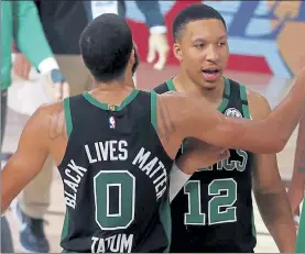  ?? GETTY IMAGES; LEFT, AP ?? Boston Celtics’ Jayson Tatum and Grant Williams react after Friday’s victory over the Miami Heat. At left, Miami’s Bam Adebayo and Boston’s Jaylen Brown battle for the ball during Friday night’s game.