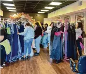  ?? Jillian Falcone/Contribute­d photo ?? Shoppers look at dresses during the Prom Closet event on March 3 at Allin Hair Studio in Cheshire.