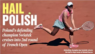  ??  ?? Defending champion Iga Swiatek returns the ball to Kaja Juvan at Roland Garros