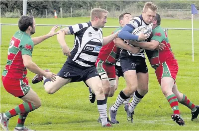  ?? Picture: Steve Lewis ?? Pwllheli (red and green) look to stop Colwyn Bay’s Pat Atkinson in his tracks