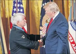  ?? [PABLO MARTINEZ MONSIVAIS/AP] ?? President Donald Trump shakes hands with retired Army medic James McCloughan after bestowing him with the Medal of Honor in a White House ceremony Monday.