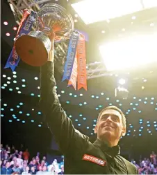  ?? — AFP photo ?? O’Sullivan poses with the trophy in the ticker tape after his victory over Trump at The Crucible in Sheffield, England.