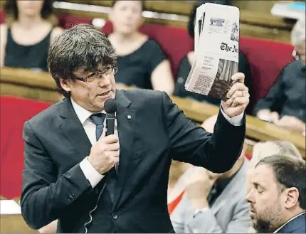  ?? ANDREU DALMAU / EFE ?? Puigdemont exhibiendo un ejemplar de The New York Times ayer en la sesión de control en el Parlament