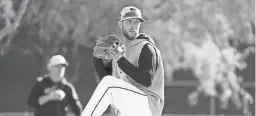  ?? ROB SCHUMACHER/THE REPUBLIC ?? DBacks pitcher Merrill Kelly throws during spring training workouts last month at Salt River Fields at Talking Stick in Scottsdale.