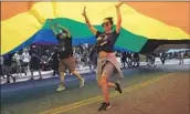  ?? VOLUNTEERS Myung J. Chun Los Angeles Times ?? keep the LGBTQ Pride flag aloft during last year’s West Hollywood Pride Parade.