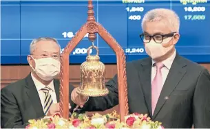  ?? AFP ?? Cambodia’s Minister of Economy and Finance Aun Porn Moniroth, right, and chairman and managing director of Acleda Bank In Channy ring a bell during the bank’s official listing ceremony yesterday.