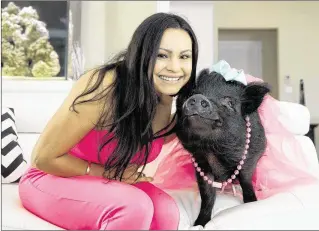  ?? ALLEN EYESTONE / THE PALM BEACH POST ?? Jahaira Zamora-Duran, 25, sits with Blue, her 3-year-old, pot-bellied therapy pig in Wellington recently. Blue has been certified as a “therapy pig” and the two visit the rehab center NuVista Living at Wellington Green multiple times a month to cheer...