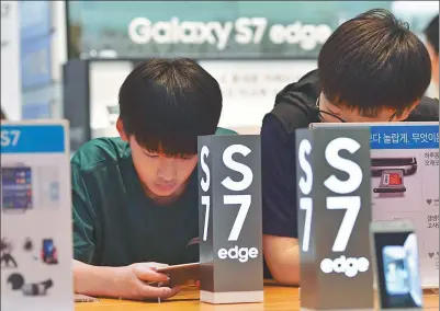  ??  ?? Visitors test Samsung Galaxy S7 edge smartphone­s at its showroom in Seoul.