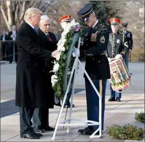  ?? AP/ EVAN VUCCI ?? President- elect Donald Trump and Vice President- elect Mike Pence place a wreath Thursday at the Tomb of the Unknowns at Arlington National Cemetery in Virginia.